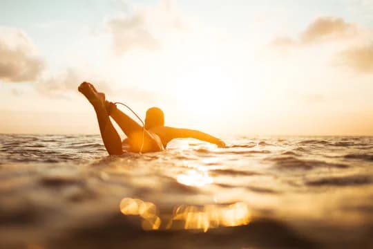 Sunlit Silhouette of Woman Surfing