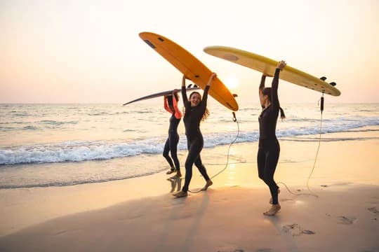 Friends Surfing on Beach with Glow of Sun
