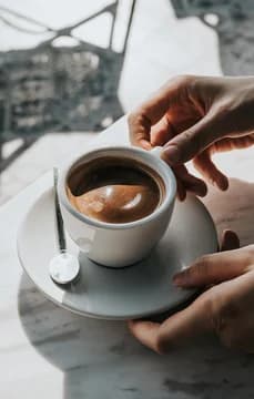 139788 Hands Holding Macchiato at Outside Caf USP Crop