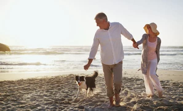Older Couple on Beach with Dog